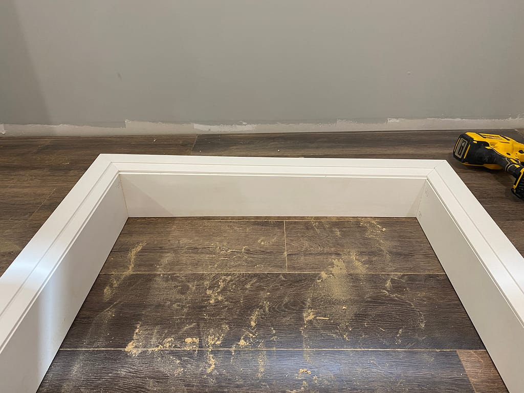 White frame prepared for uneven plaster wall by finish carpenter Jack