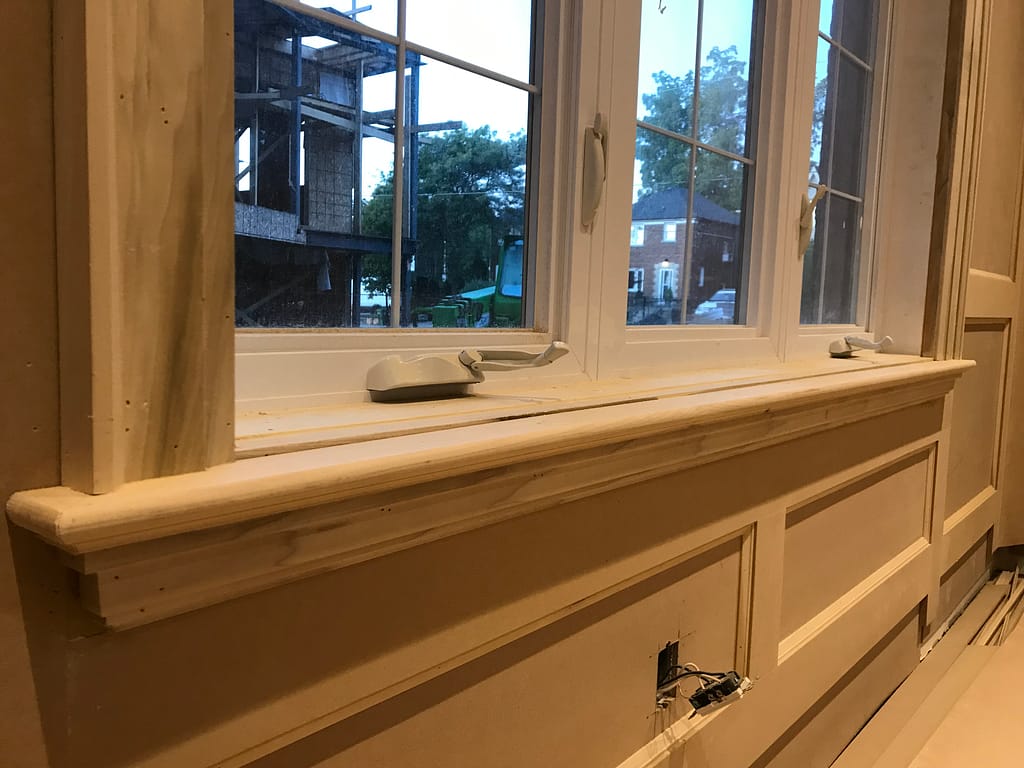Poplar window casing with backband, stool and apron installed above painted wall panels
