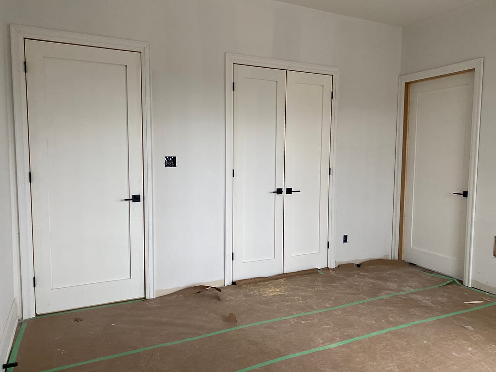 One-panel solid-core shaker interior doors installed with black hardware