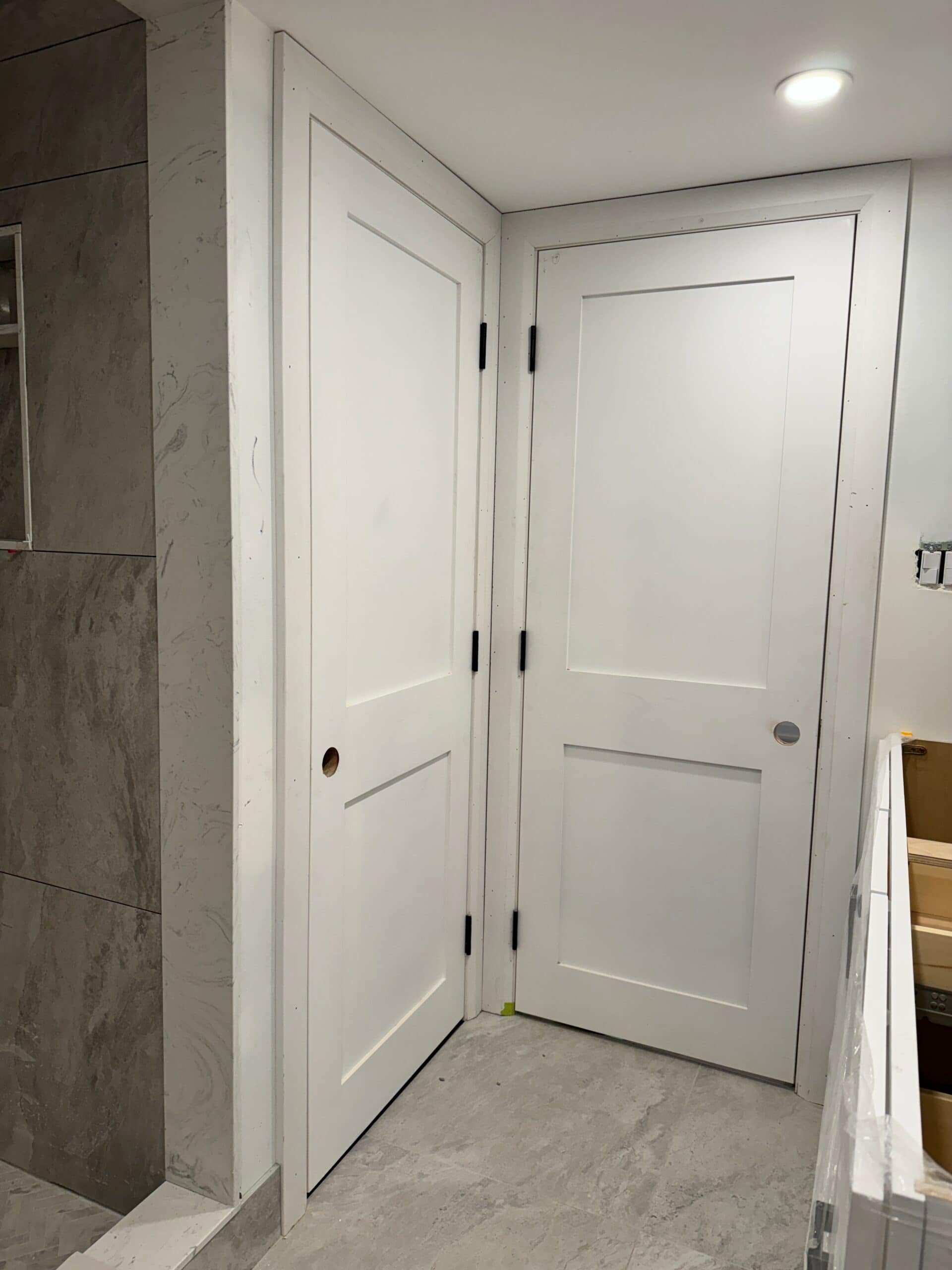 White two-panel shaker bathroom and bedroom entry doors installed side by side