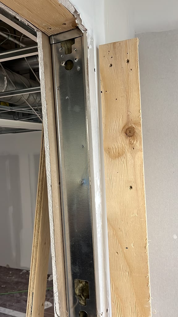 Finish carpenter reviewing door openings on a renovation job site.