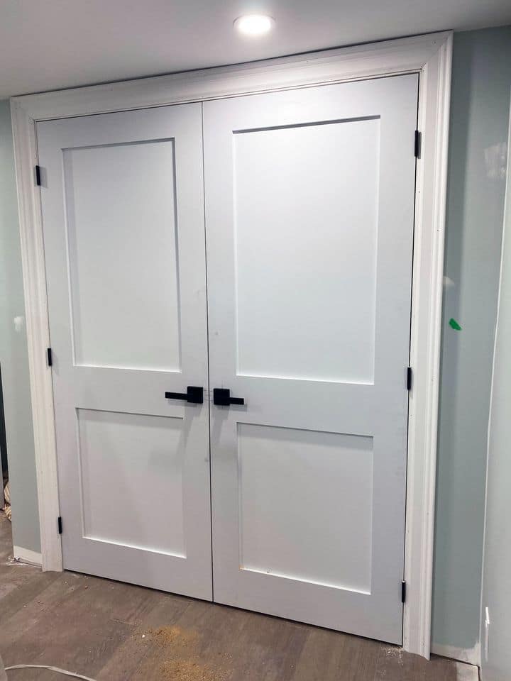 Two-panel shaker style interior double doors installed with black hinges and hardware in Guelph