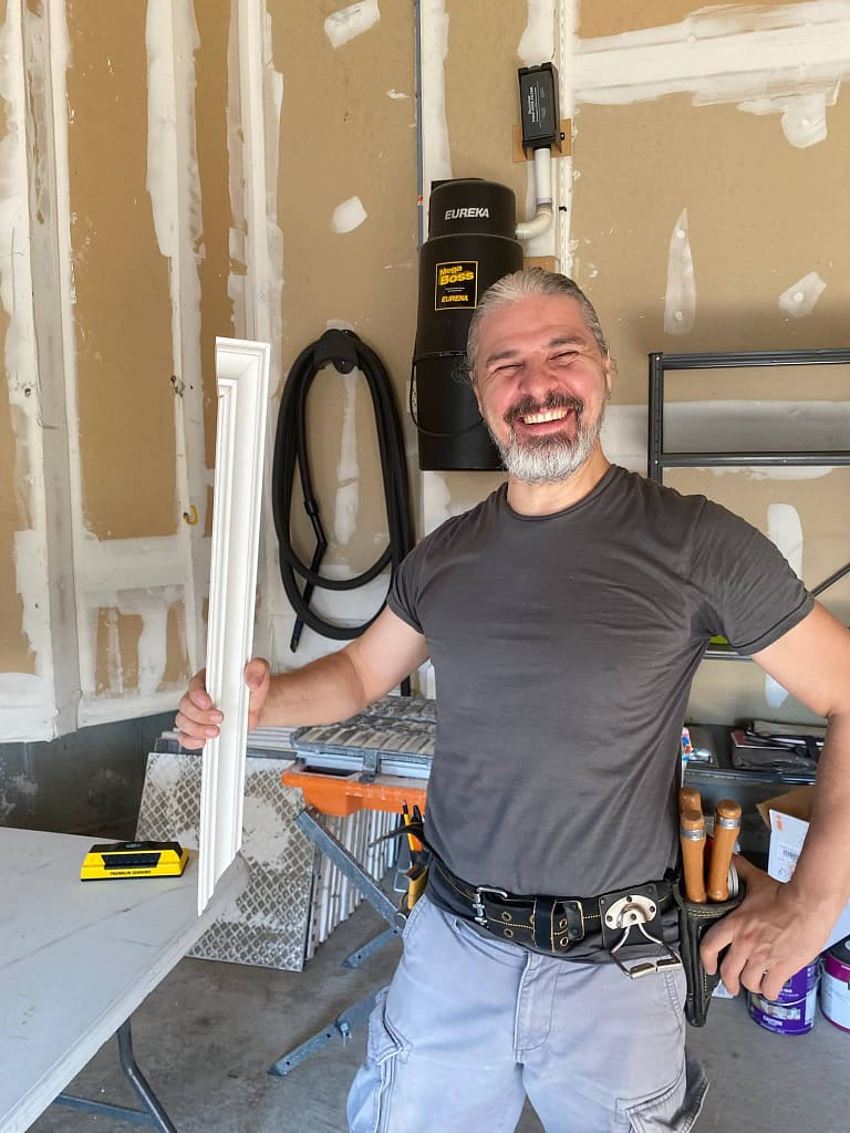 Finish carpenter Jack Cenk Ozer holding a piece of crown moulding