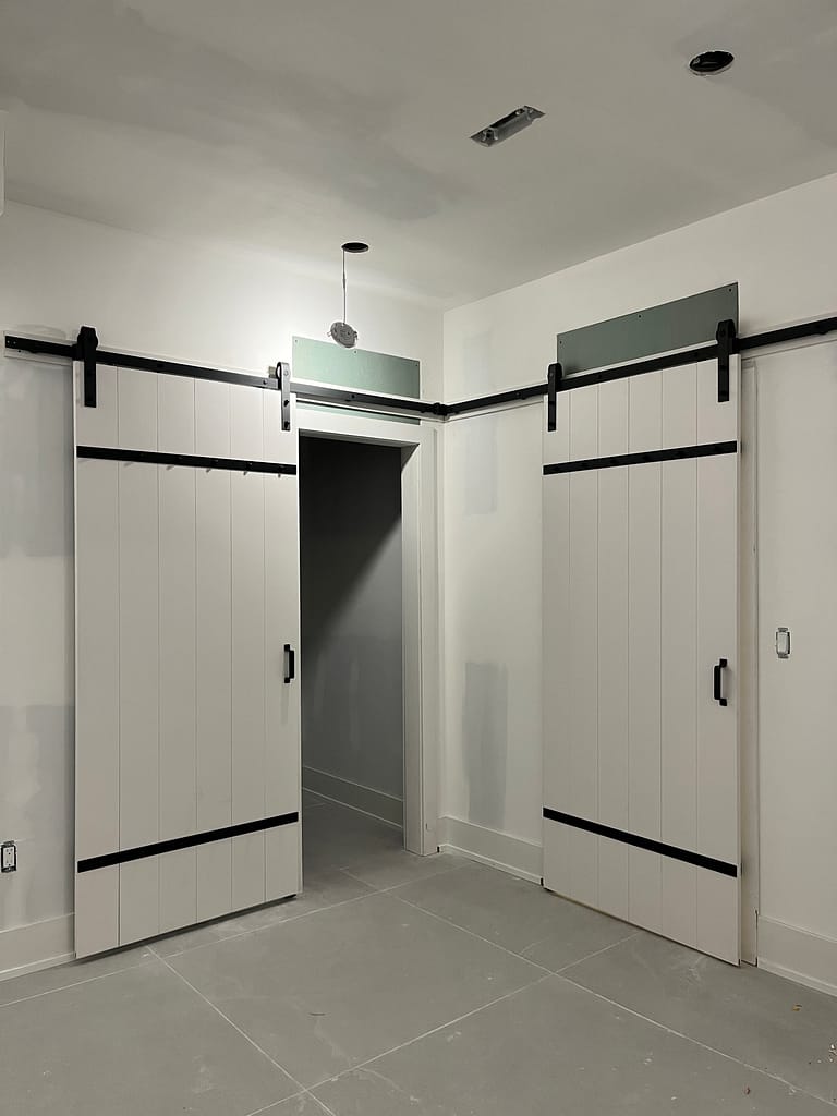 Open twin barn doors showing custom interior storage access