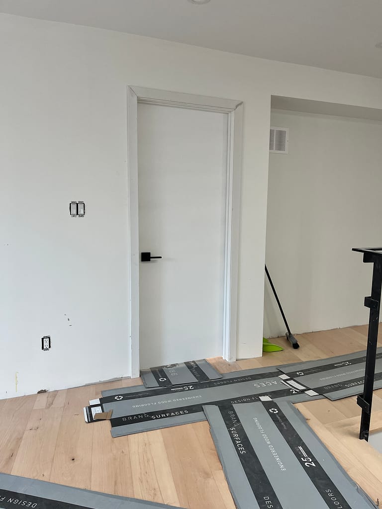 Laser-guided leveling and plumb line adjustments during a premium interior door replacement setup in an Oakville custom house.