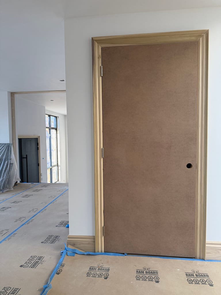 Tall interior elevator door with natural casing near the main living area of a Toronto home