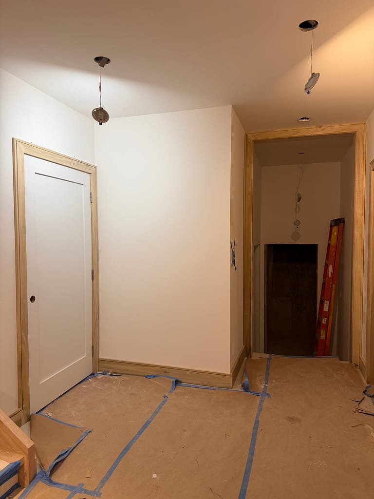 Full basement hallway with tall interior doors, casing and baseboards in a Toronto home
