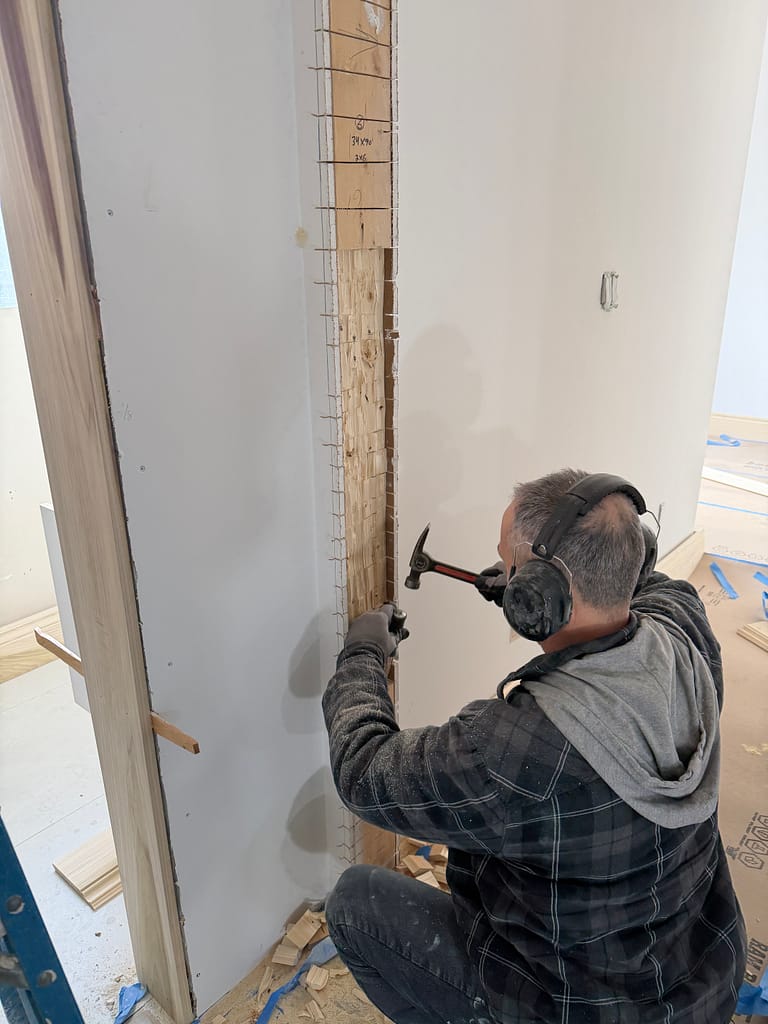 Carpenter widening a rough opening for an 8-foot interior door in Toronto