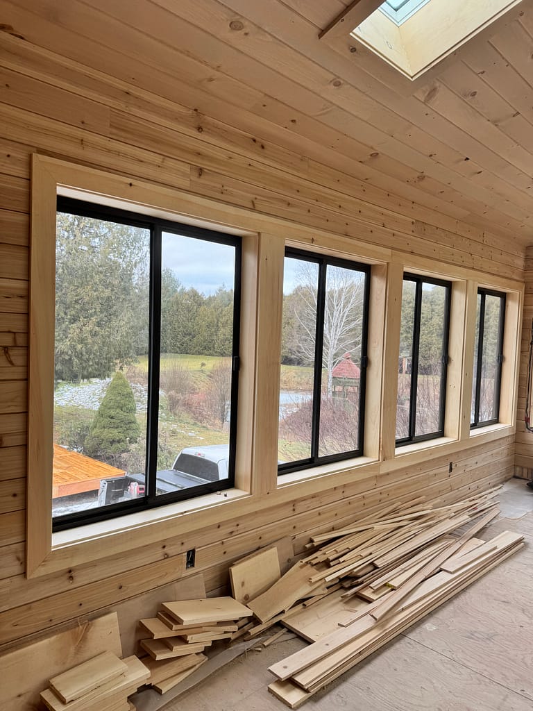 Long window wall with shiplap and custom wood casing in an Oakville cabin-style addition