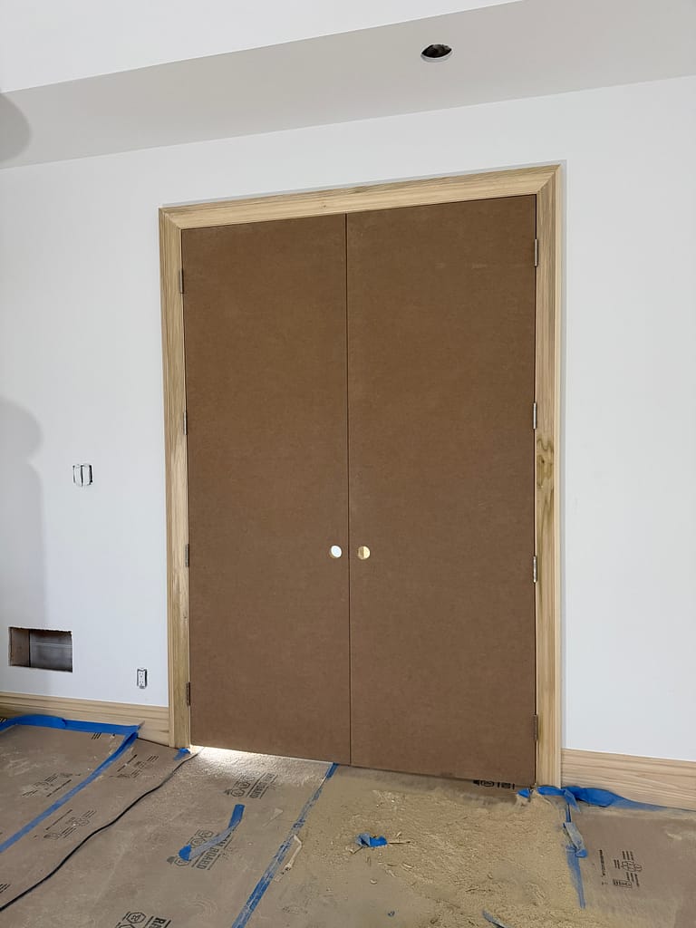 Tall double interior doors with natural wood casing installed in a Toronto home