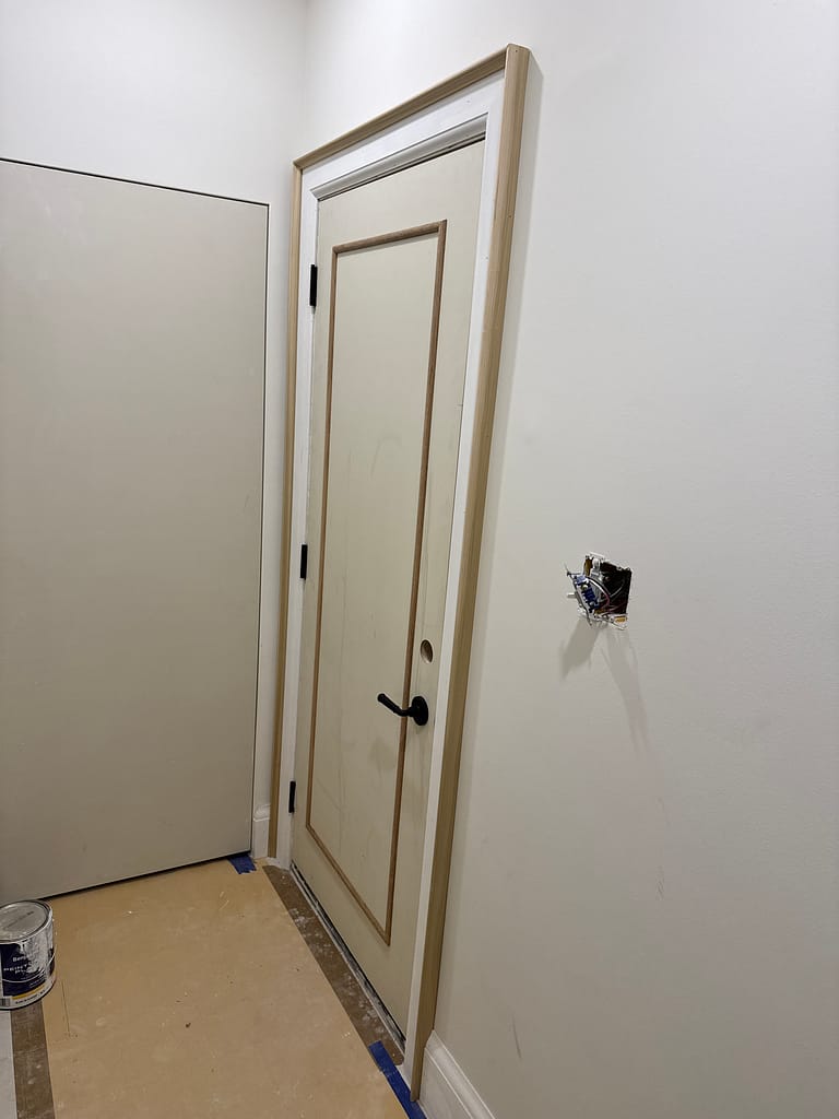 Fire-rated garage access door customized with applied molding and wide wood casing during a Vaughan project.