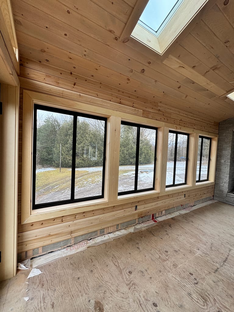 Wide window wall with natural shiplap interior and wood trim in an Oakville room addition