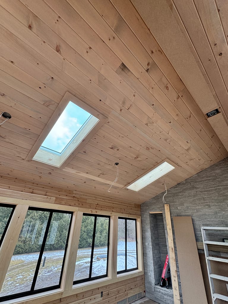 Wood shiplap ceiling with skylights in an Oakville cabin-style room addition