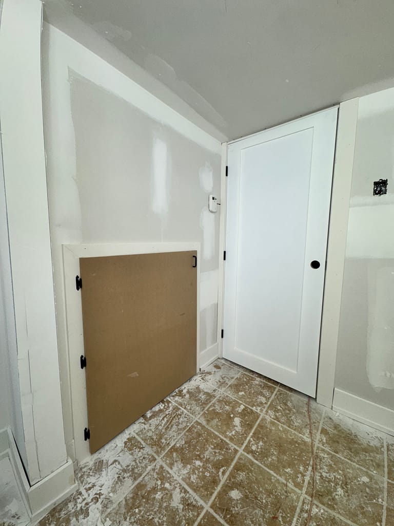 Small basement storage door and full-size interior door installed with casing in the same basement area.