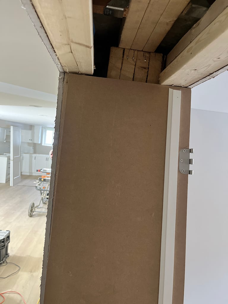 Door jamb and wall thickness being checked before trim installation.