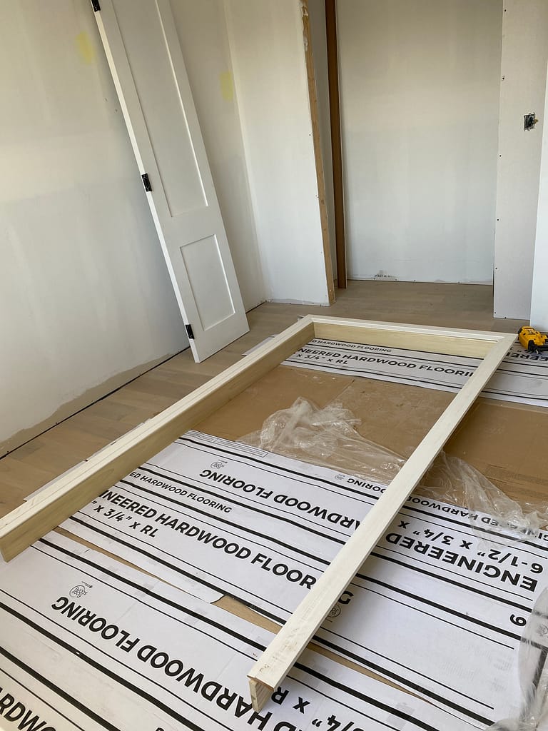 Custom door jamb and casing assembly prepared on the floor for a solid-core interior door in Oakville.