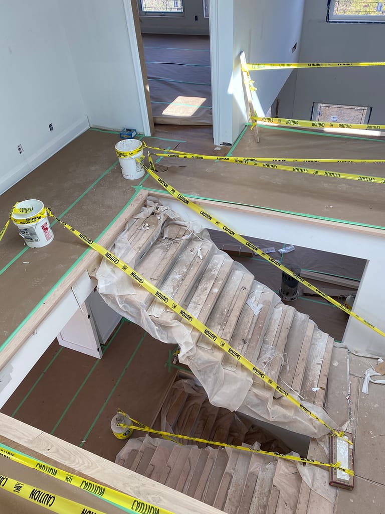 Protected stair area during finish carpentry work in a new construction Oakville home