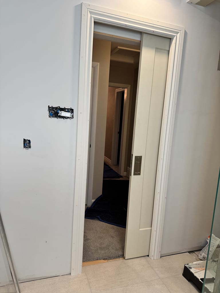 Open pocket door with Emtek privacy hardware and casing in Oakville