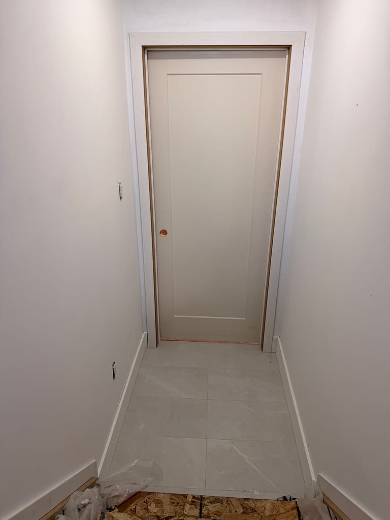 Short one-panel basement door showing handle placement after the door was fitted to a low opening.