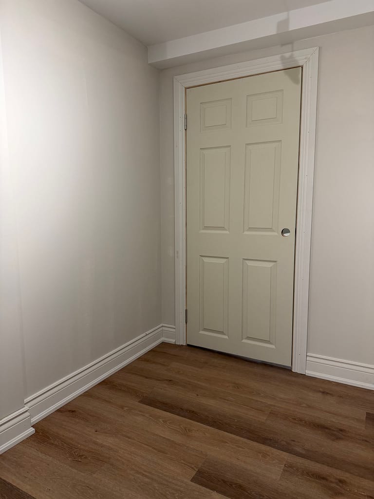 Six-panel basement door showing why panel layout matters when deciding handle height on a short door.