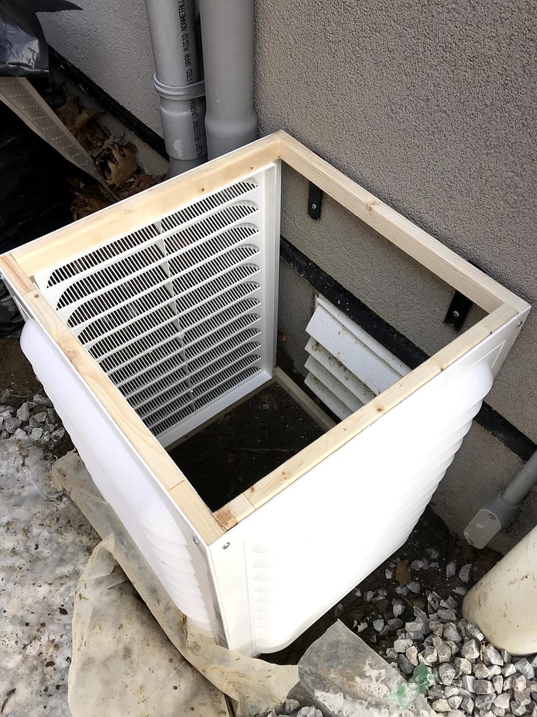 Custom snow guard fitted around a low exterior wall vent in Mississauga