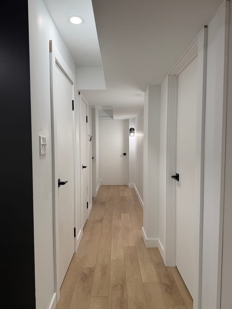 Hamilton basement hallway with multiple custom-fitted doors, flat-stock casing and baseboards