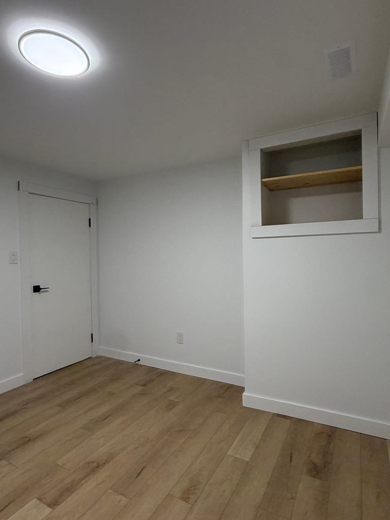 Custom-height flush interior door installed with black hinges and flat-stock casing