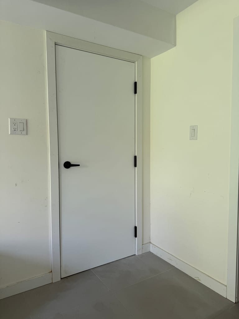 New flush fire-rated garage entry door with black hardware installed in Burlington