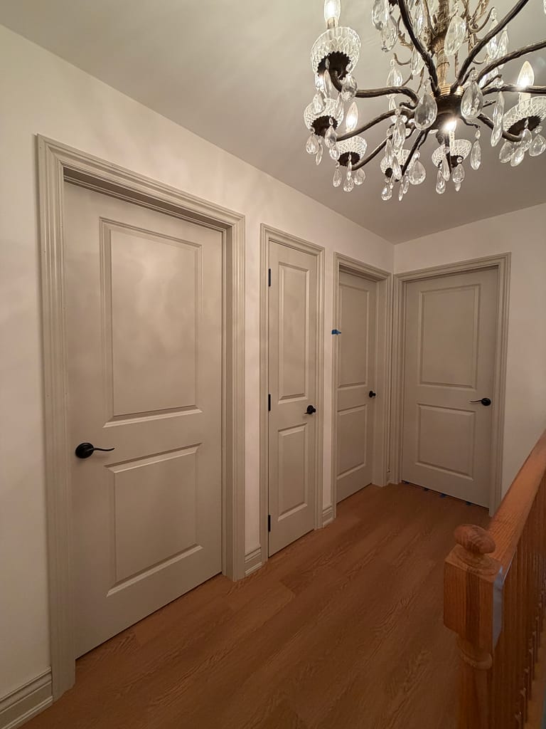 Milton upstairs hallway with multiple prefinished interior doors and traditional casing