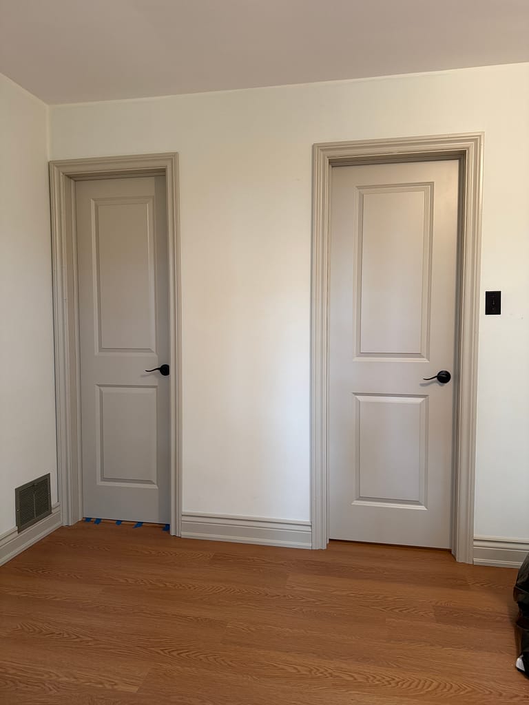Two prefinished interior doors with detailed casing and baseboards in a Milton home