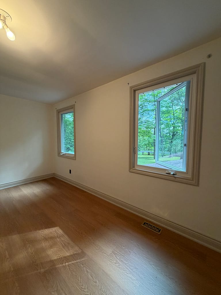 Two Milton bedroom windows finished with custom jamb extensions and traditional casing
