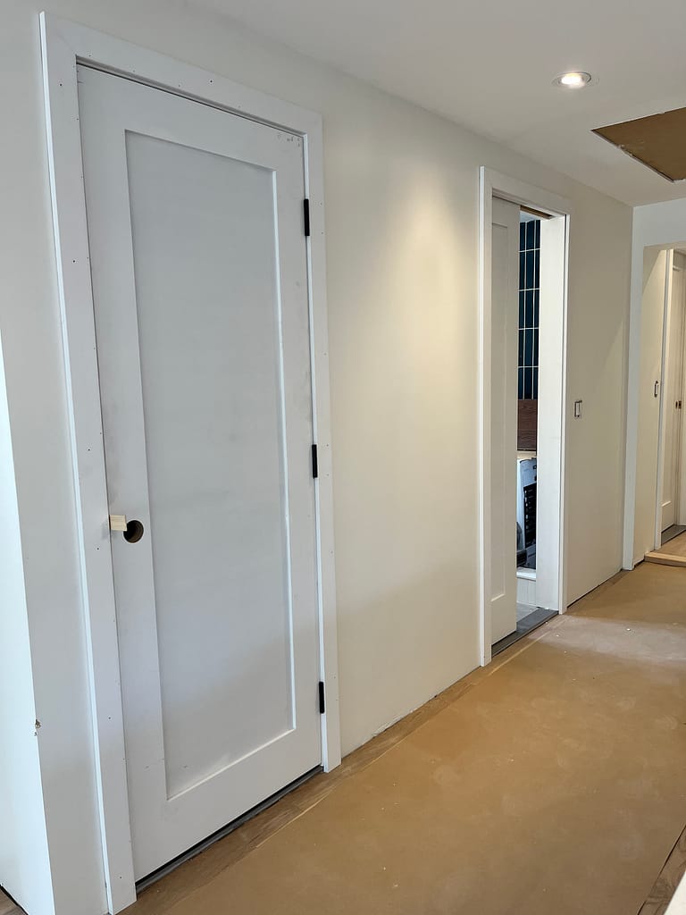 Interior hallway with hinged and pocket-door openings during installation in Port Credit