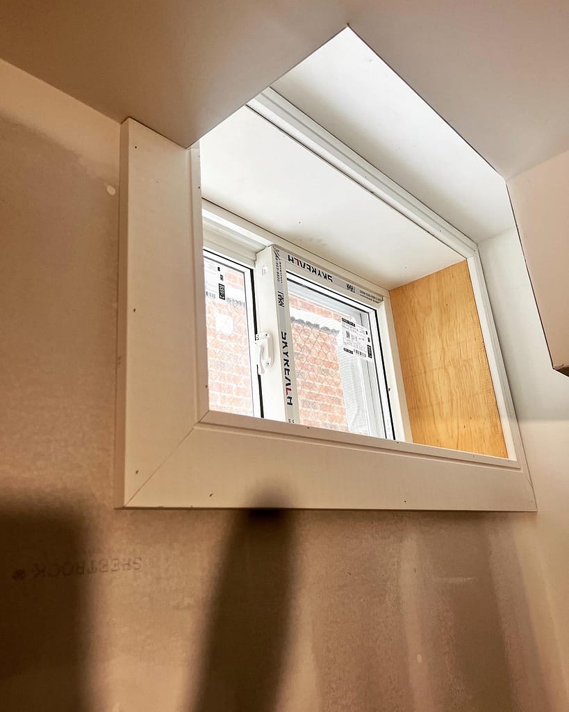 Framed basement window with trim in Milton