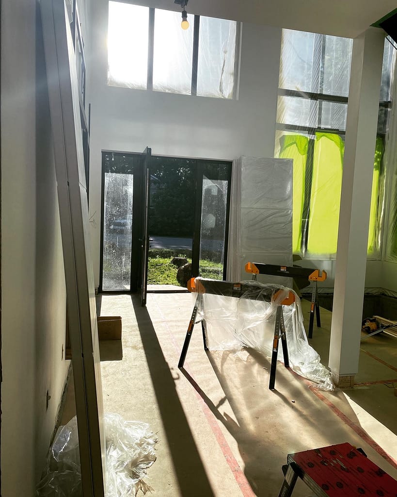 Oakville custom home jobsite with tall windows, protected floors and 96-inch solid-core doors ready for installation.