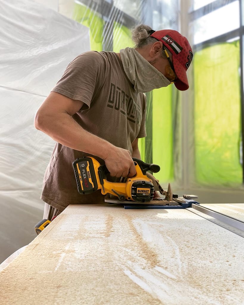 Finish carpenter Jack using a guided saw to reduce the width of a 96-inch solid-core interior door in Oakville.