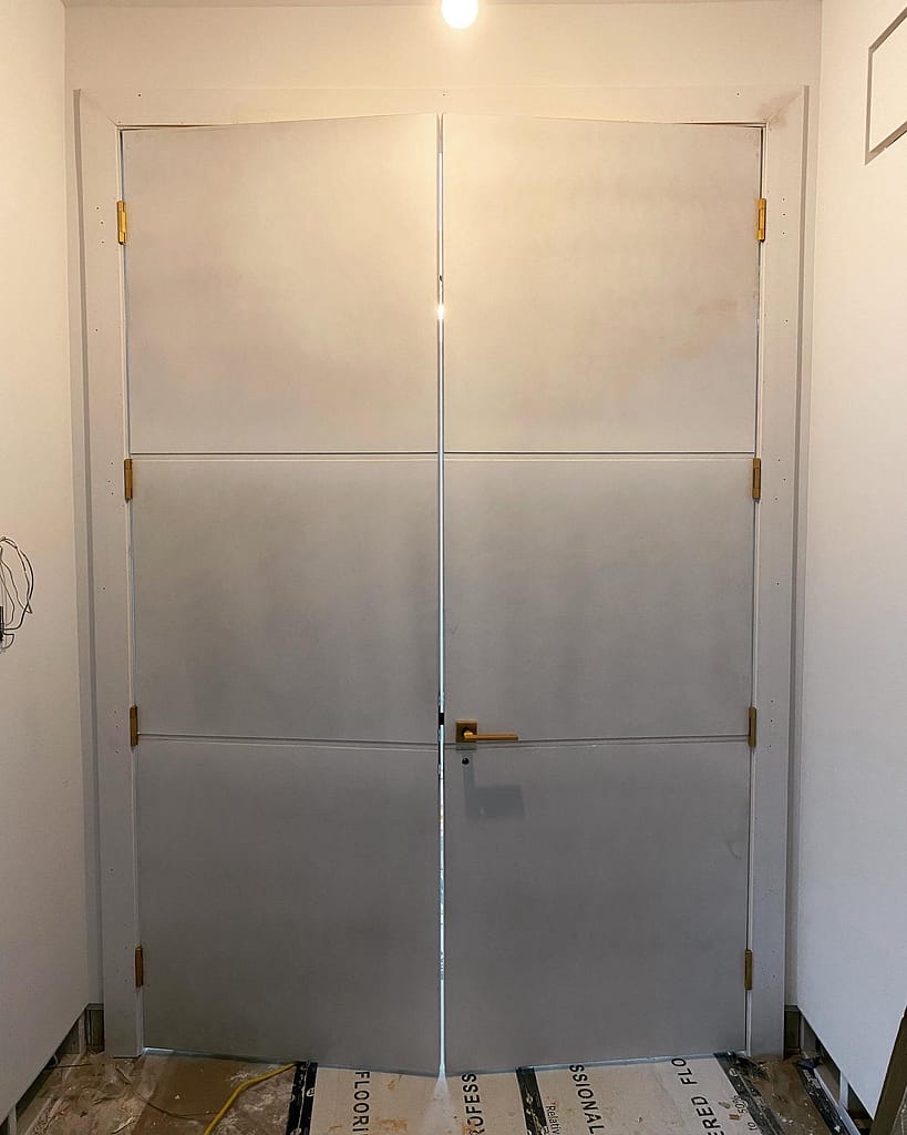 Pair of 96-inch solid-core double doors installed with brass hinges and custom casing in an Oakville home.