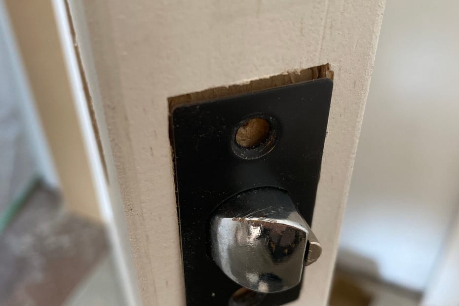 Close-up of an interior door latch bolt and black latch faceplate