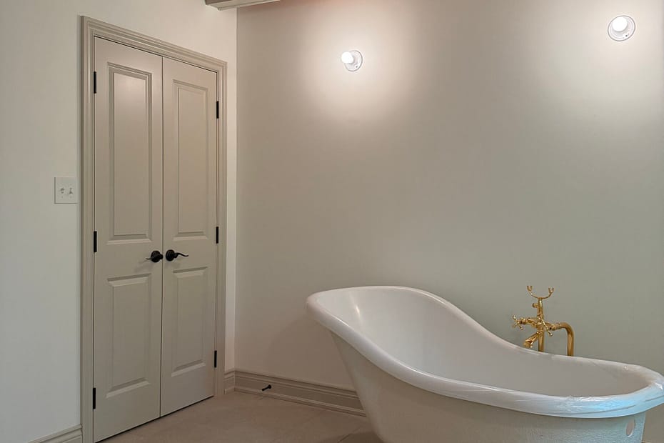 Finished Milton bathroom with double closet doors, custom beam covers, baseboards and traditional trim
