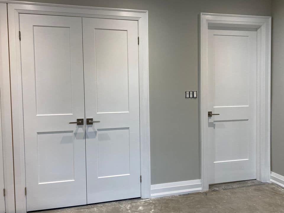 Double and single two-panel Shaker doors installed with casing, backband and satin nickel hardware