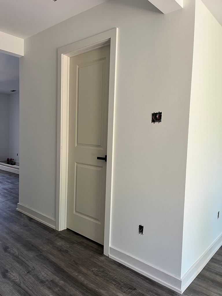 Close view of interior door casing and trim installation with baseboard in a Milton renovation.