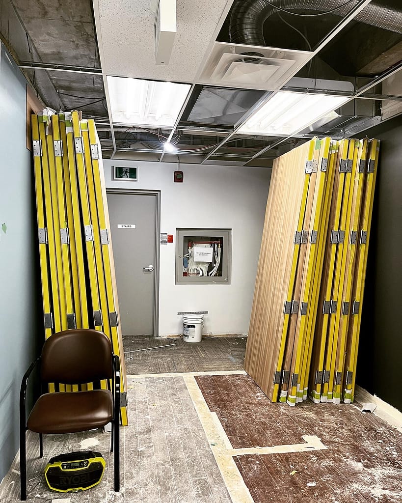 Staging and organizing 32 premium interior door slabs and heavy duty hardware components inside a Mississauga commercial project by Wood Job Finish Carpentry.