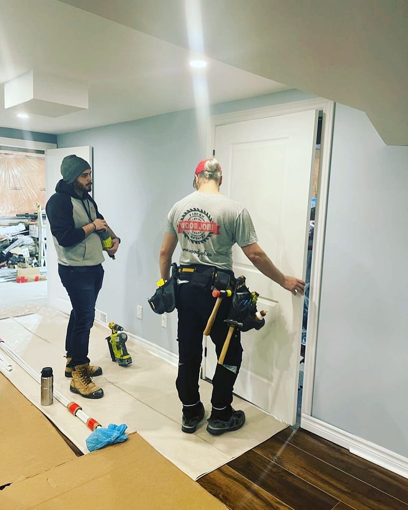 the finish carpenter is installing a door in a Milton home