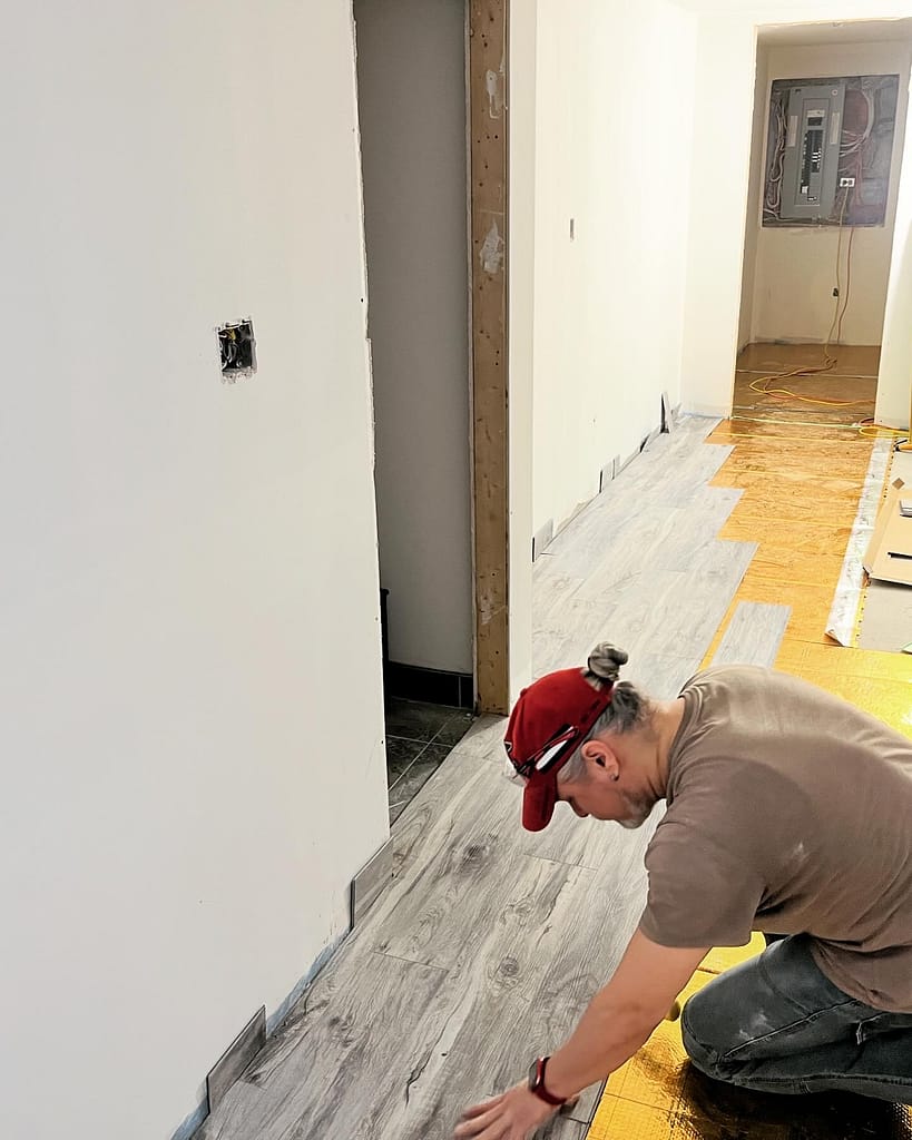 The finish carpenter Jack Cenk Ozer installing vinyl flooring during a Vaughan basement renovation
