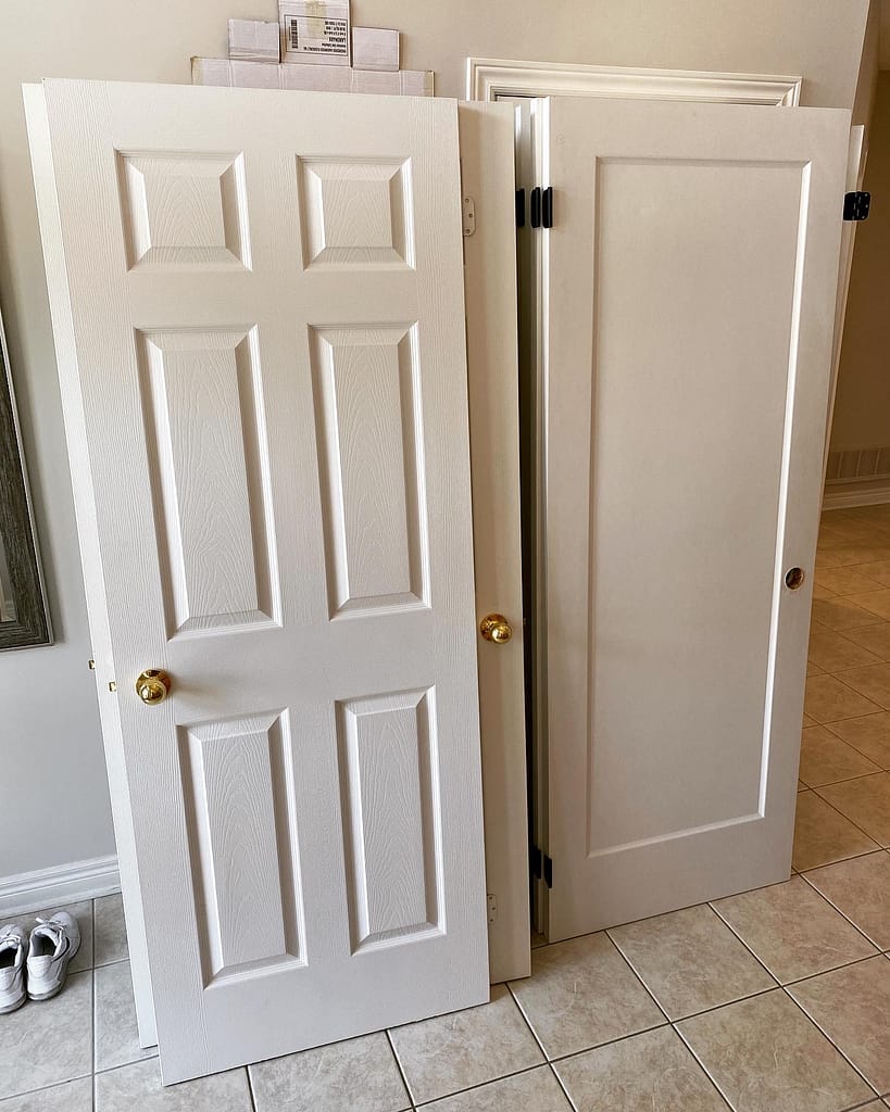 Old six panel doors and new one panel shaker doors are side by side in a Vaughan home.