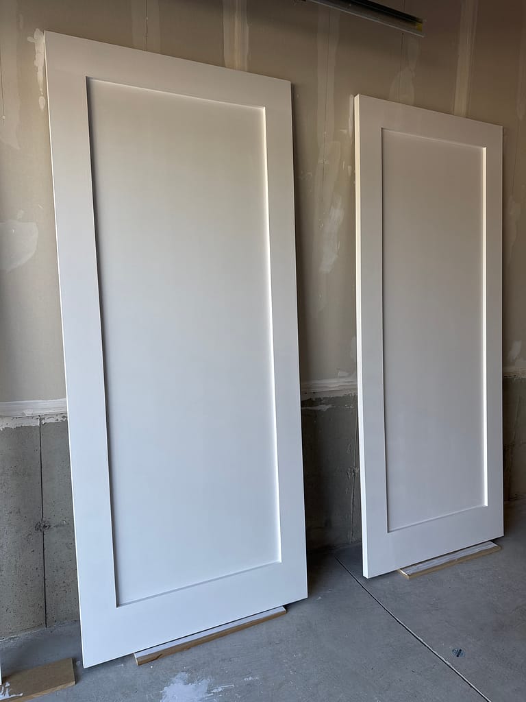Primed custom closet doors prepared for installation in a Hamilton condo