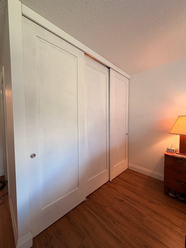 Finished one-panel shaker closet doors installed in a Hamilton condo
