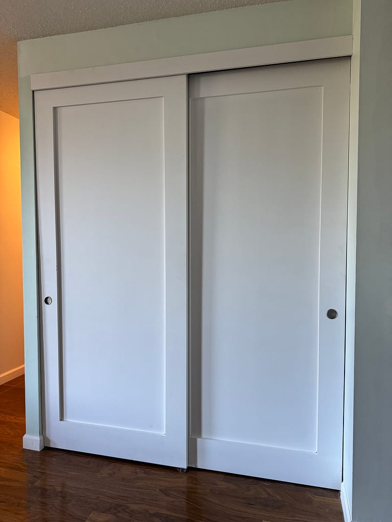 Finished one-panel shaker closet doors installed in a Hamilton condo